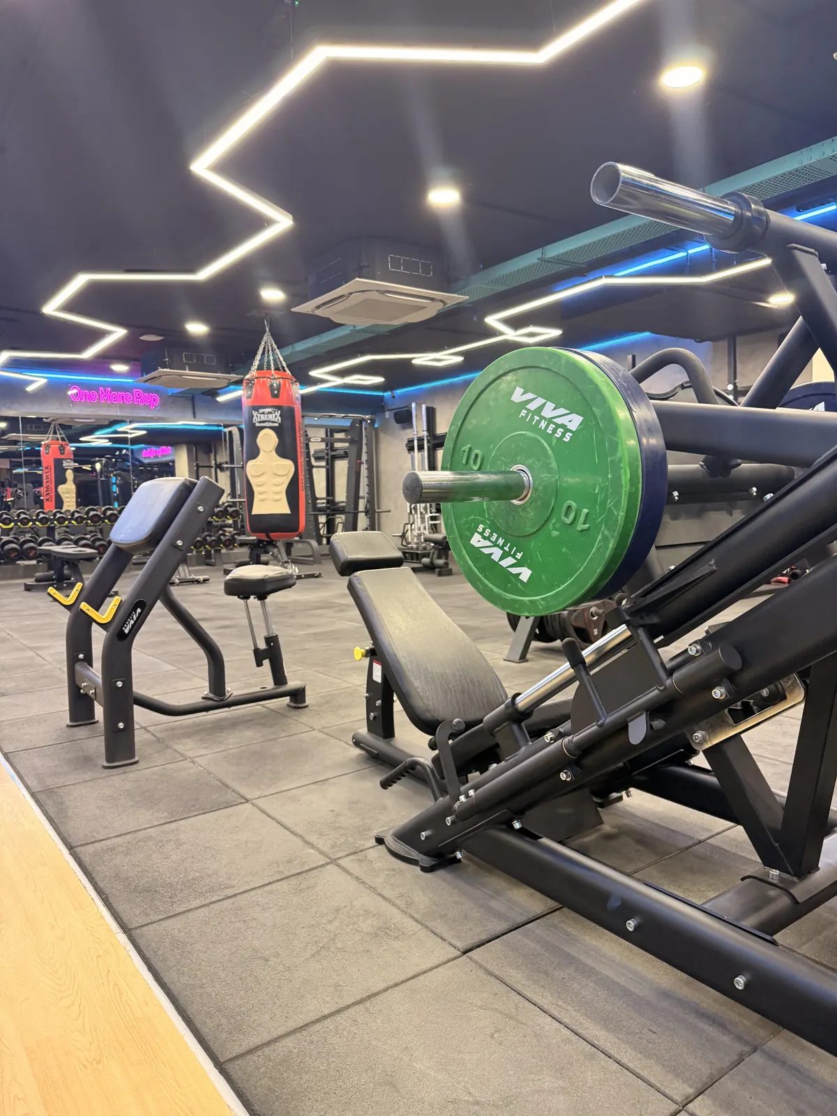The Fisique Fitness strength floor in Kokapet: dumbbell rack, benches and plate-loaded machines, empty and ready